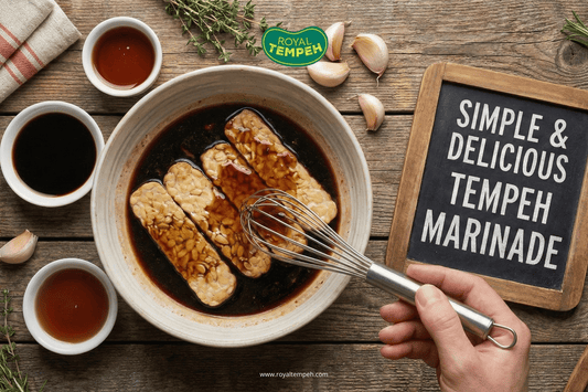 Tempeh slices soaking in a dark marinade bowl with a hand whisking the sauce.
