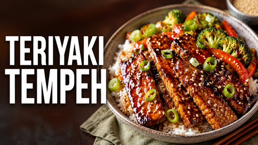 A white bowl filled with white rice, steamed broccoli, red bell peppers, and pan-seared Royal Tempeh strips coated in a dark, glossy teriyaki sauce with sesame seeds, featuring text overlay 'TERIYAKI TEMPEH'.