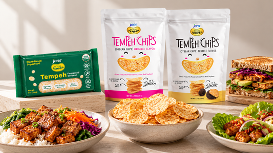 An array of Jans brand products including green packages of Royal Tempeh, Original and Truffle flavor Tempeh Chips, and bowls of prepared tempeh dishes on a wooden table.
