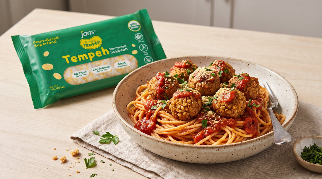 A bowl of spaghetti topped with marinara sauce, parsley, grated cheese, and golden crispy tempeh meatballs, displayed next to a green package of Jans Royal Tempeh Fermented Soybean.