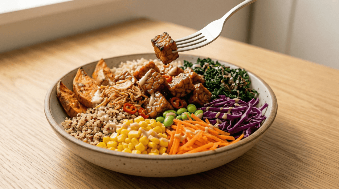 A vibrant easy tempeh power bowl featuring marinated Royal Tempeh cubes, edamame, corn, shredded carrots, and purple cabbage served over grains.