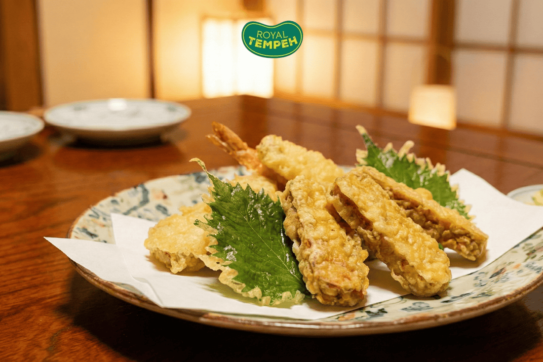 Crispy tempura-style tempeh and shrimp served on plate with shiso leaf garnish.