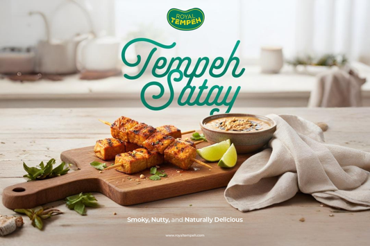 Royal Tempeh Satay skewers on a wooden board with peanut sauce and lime, tagline reads ‘Smoky, Nutty, and Naturally Delicious.