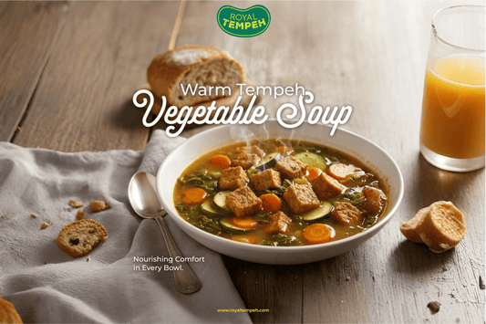 Royal Tempeh vegetable soup with carrots, zucchini, and tempeh cubes served with bread.