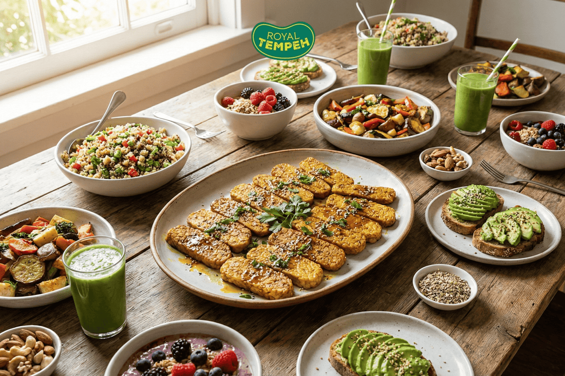 Healthy plant-based meal spread with grilled tempeh, grain salads, roasted vegetables, avocado toast, berries, and green smoothies on a wooden table.