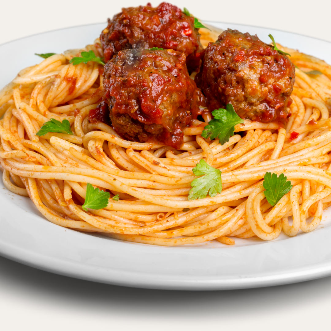 Plate of spaghetti topped with tomato sauce, meatballs, and fresh parsley.