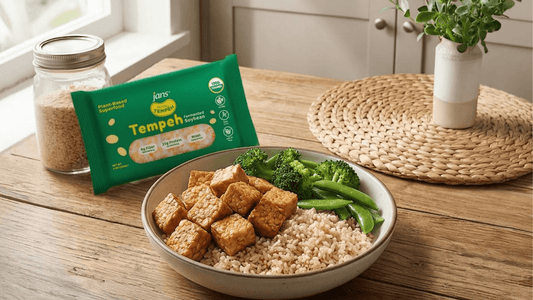A package of Royal Tempeh next to a prepared bowl of cubed tempeh, brown rice, and broccoli on a wooden dining table.