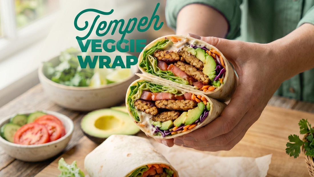 Two halves of an easy tempeh breakfast burrito held up to show a filling of seasoned Royal Tempeh strips, sliced avocado, purple cabbage, and fresh greens.
