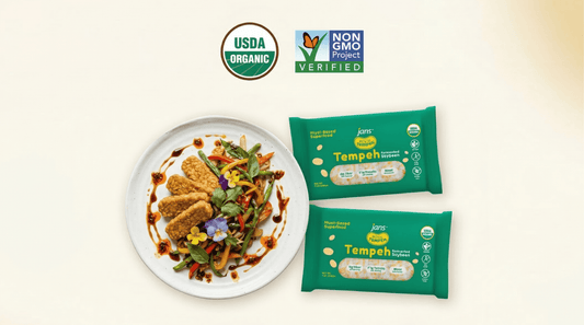 Packages of Royal Tempeh displayed next to a prepared dish, featuring the USDA Organic and Non-GMO Project Verified seals.